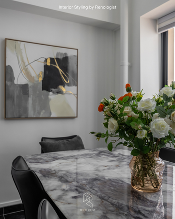 Elegant dining area in an HDB Executive Maisonette featuring professional interior styling with fresh floral arrangements, curated wall décor, modern dining furniture, and decorative accents that create a sophisticated, hotel-inspired ambience.
