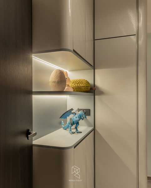 Custom built-in display niche with integrated LED lighting, concealed storage, and rounded shelving, showcasing decorative collectibles in a modern contemporary home.