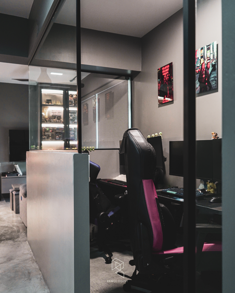 Glass-partition study room with black-framed windows, dual workstations, cement screed flooring, and a minimalist industrial interior.