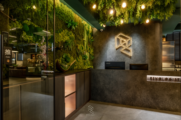 Renologist office reception with dark stone finishes, hanging plants and an open-concept showroom.