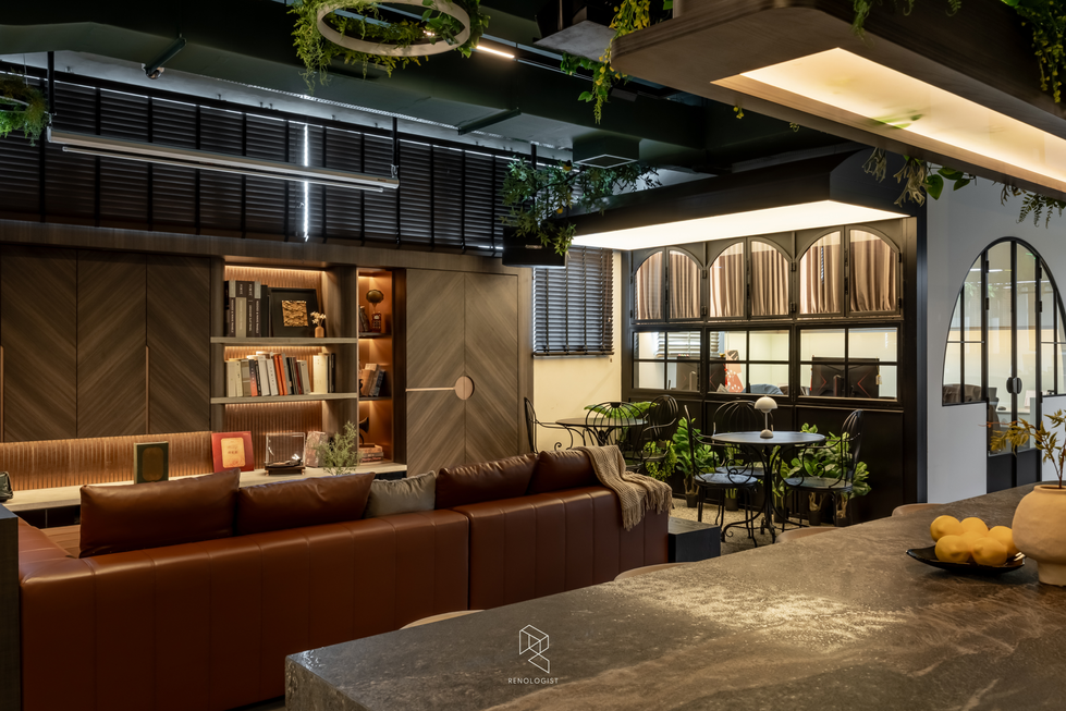 Modern office lounge with brown leather sofas, bespoke TV cabinetry and illuminated display shelves.