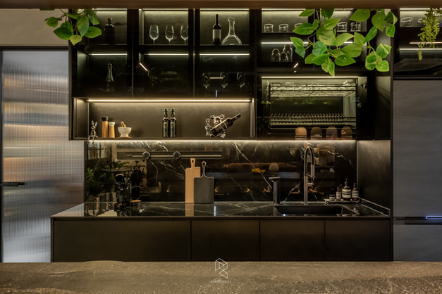 Luxury black pantry featuring marble-look surfaces, integrated dish storage and full-height cabinetry.