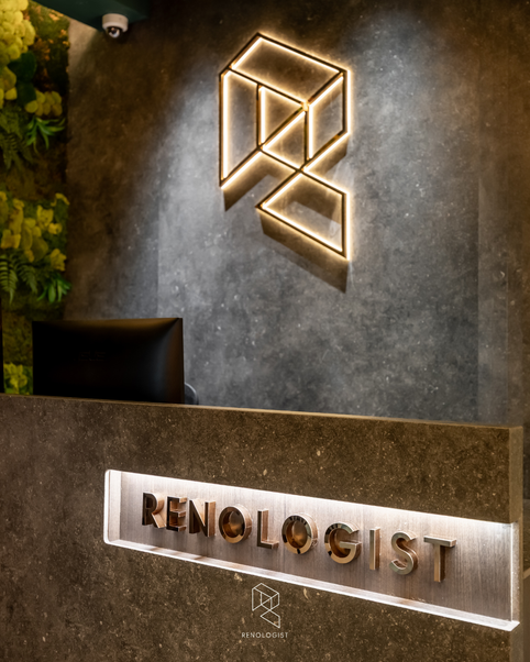 Renologist office reception with dark stone finishes, hanging plants and an open-concept showroom.