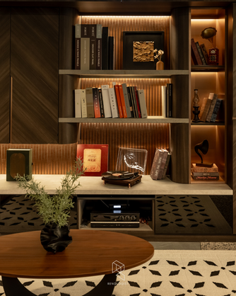 Modern office lounge with brown leather sofas, bespoke TV cabinetry and illuminated display shelves.