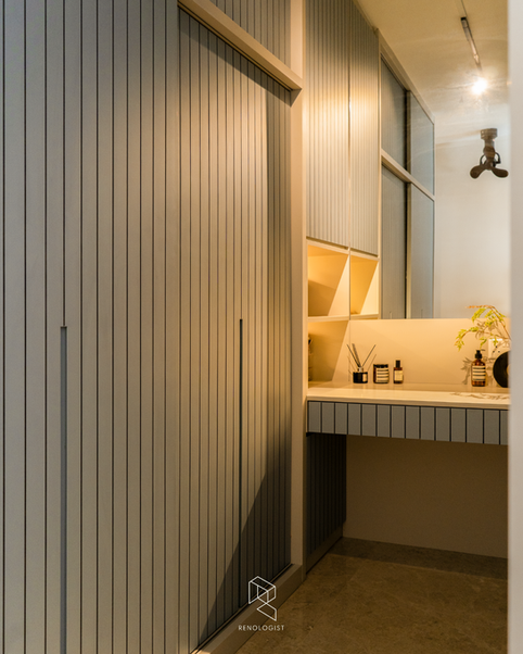 Walk-in wardrobe with full-height fluted wardrobes, built-in dressing table, illuminated display shelves, and warm ambient lighting in a Modern Contemporary home.