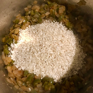 Once the onions and peppers are soft, toast the rice on the bottom of the pot