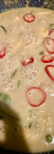 Add the water and the mild red chillies and simmer