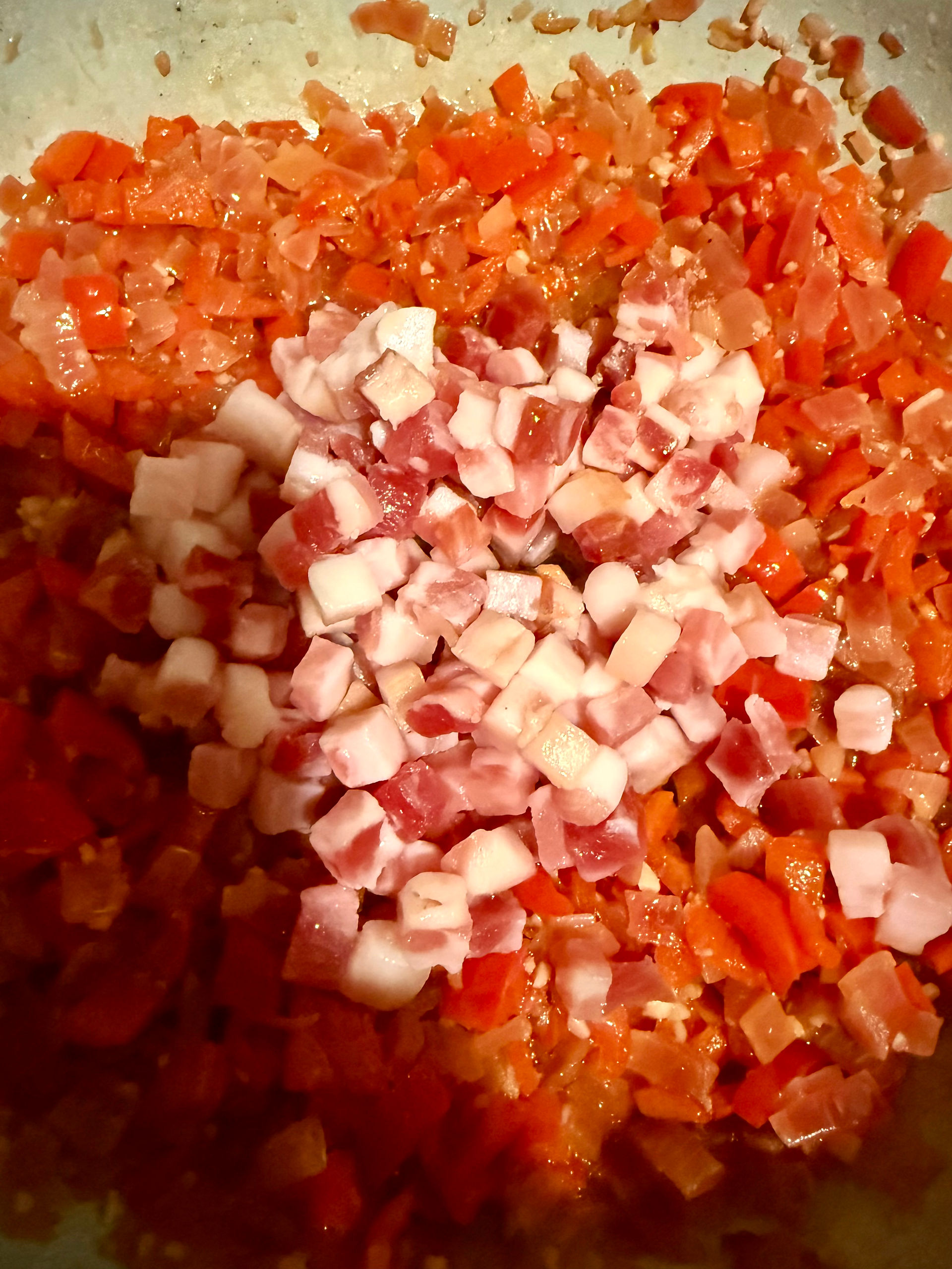 When the wine has largely cooked off, add the cubes of pancetta 