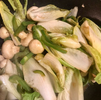 Add the chicory leaves and small whole mushrooms once the green bell pepper softens