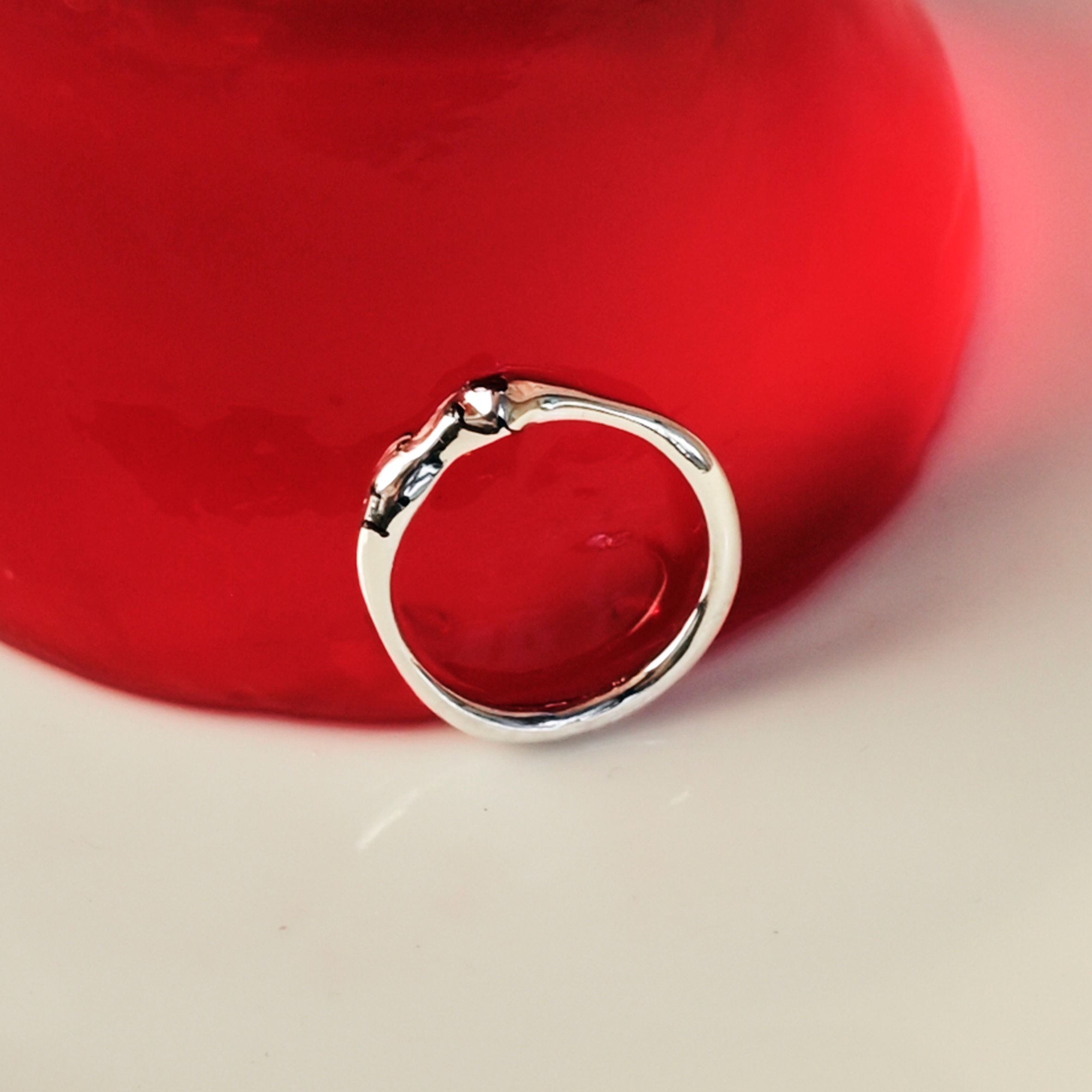 autorský stříbrný prsten s granáty a nepravidelným tvarem na červeném želé