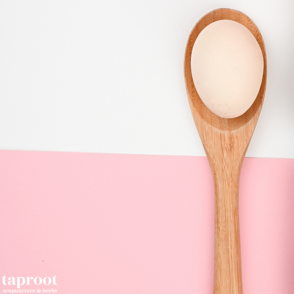 a wooden spoon with an egg inside, on a white and pink background