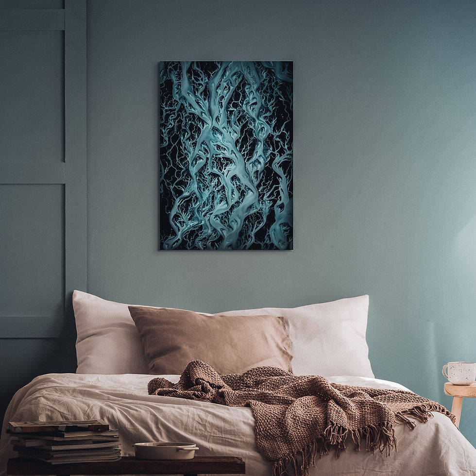 Thumbnail: Print of blue flowing rivers from above, hung over a bed