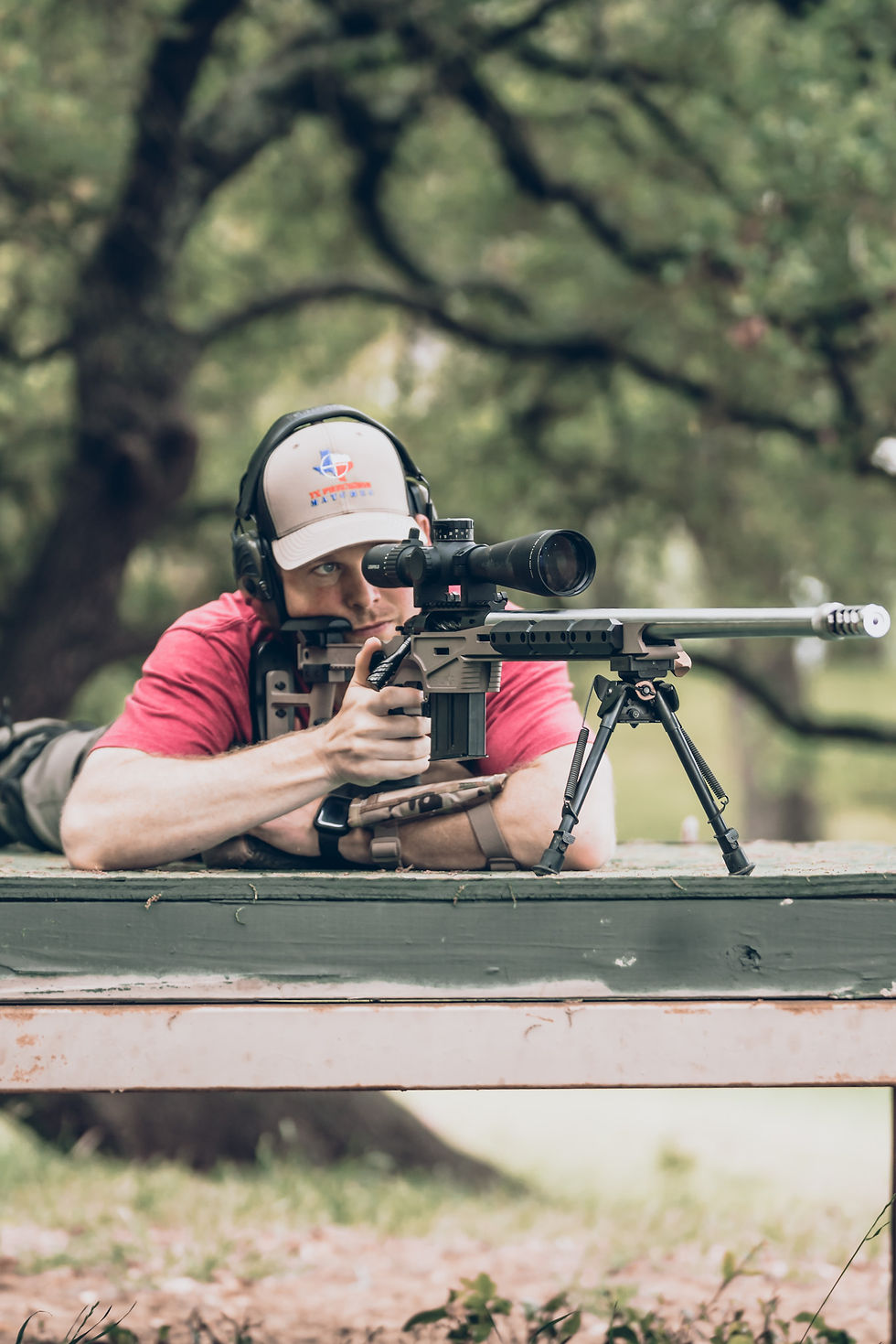 Eye-level view of a shooter adjusting a high-tech rifle scope