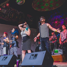 The PepTides performing live at an outdoor concert venue.