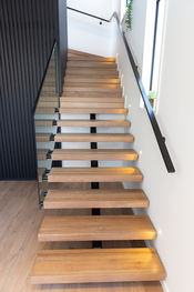 The floating addition has a seamless transition to the pre-existing wooden staircase.