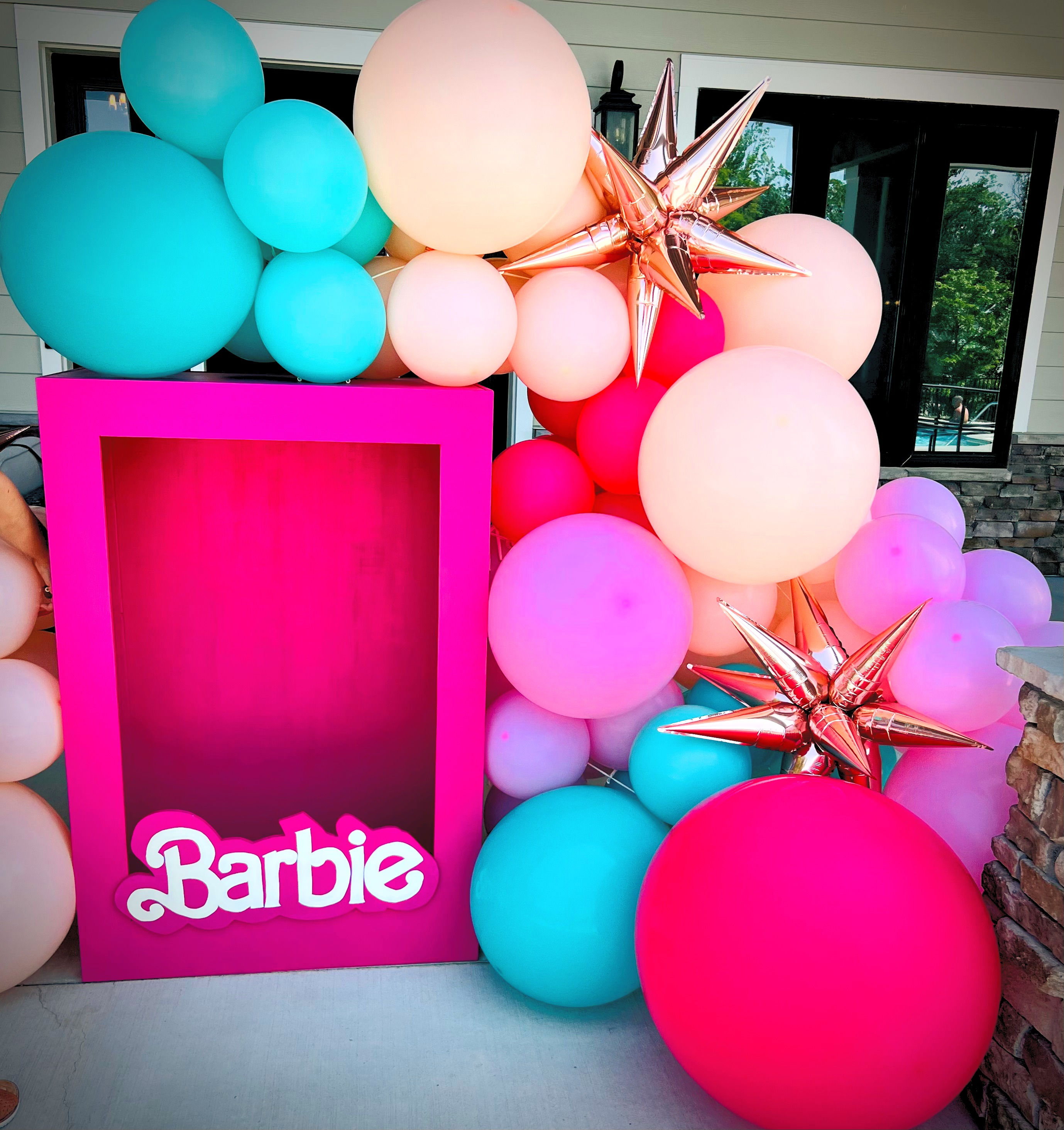 4 ft wooden barbie box prop with teal, peach and hot pink balloon garland.