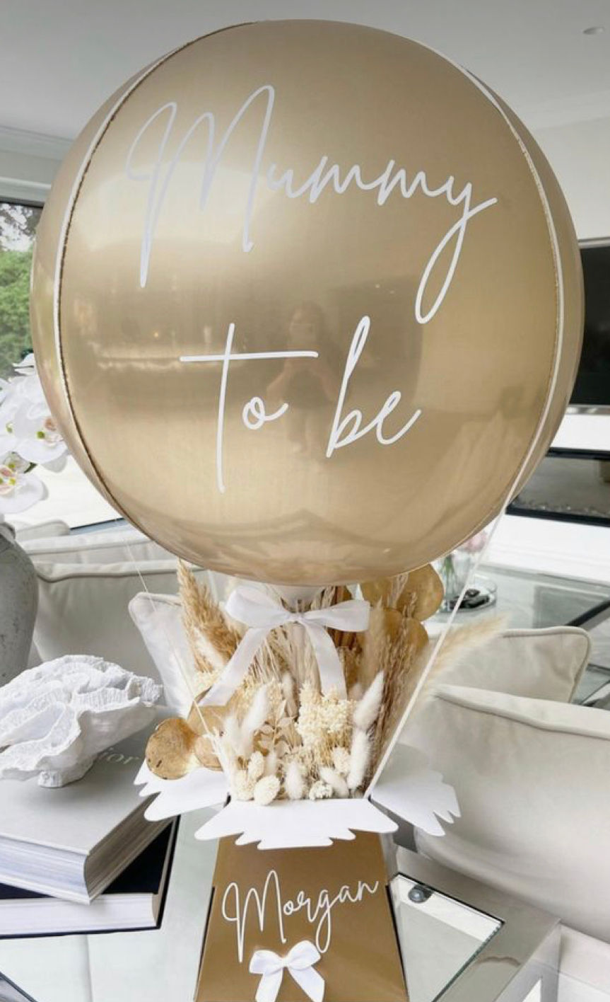 Thumbnail: gold balloon made to look like hot air balloon with Mom to Be written on it