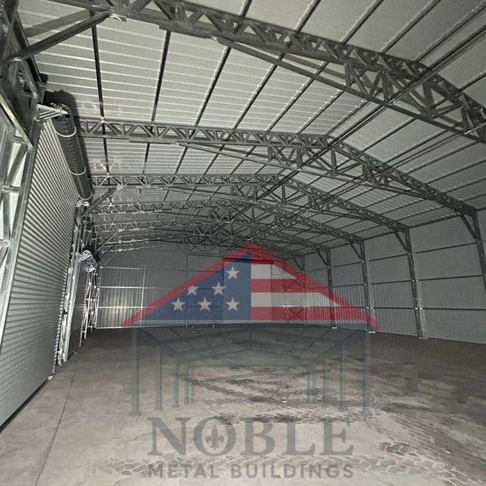 Interior view of a large clear span Texas metal warehouse with high ceilings and steel truss system, open commercial space.