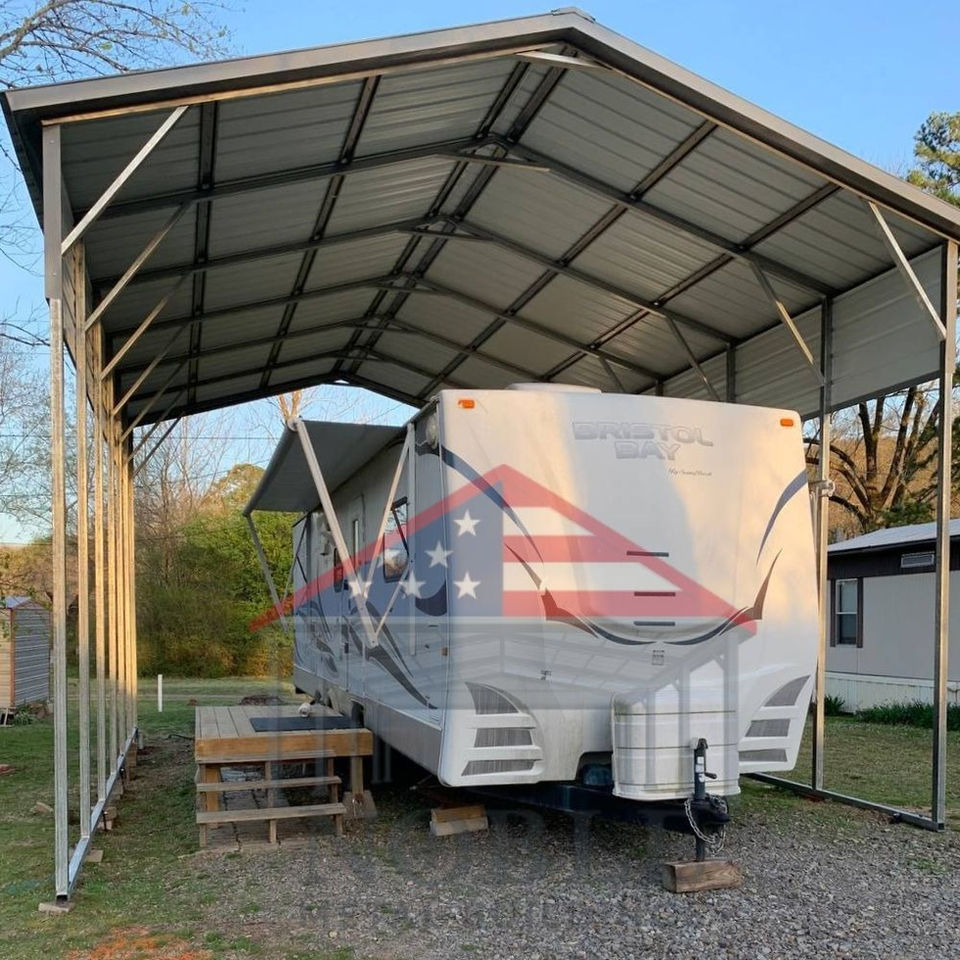 Tall metal RV cover with white roof sheltering a large fifth-wheel RV on gravel, durable Texas steel carport.