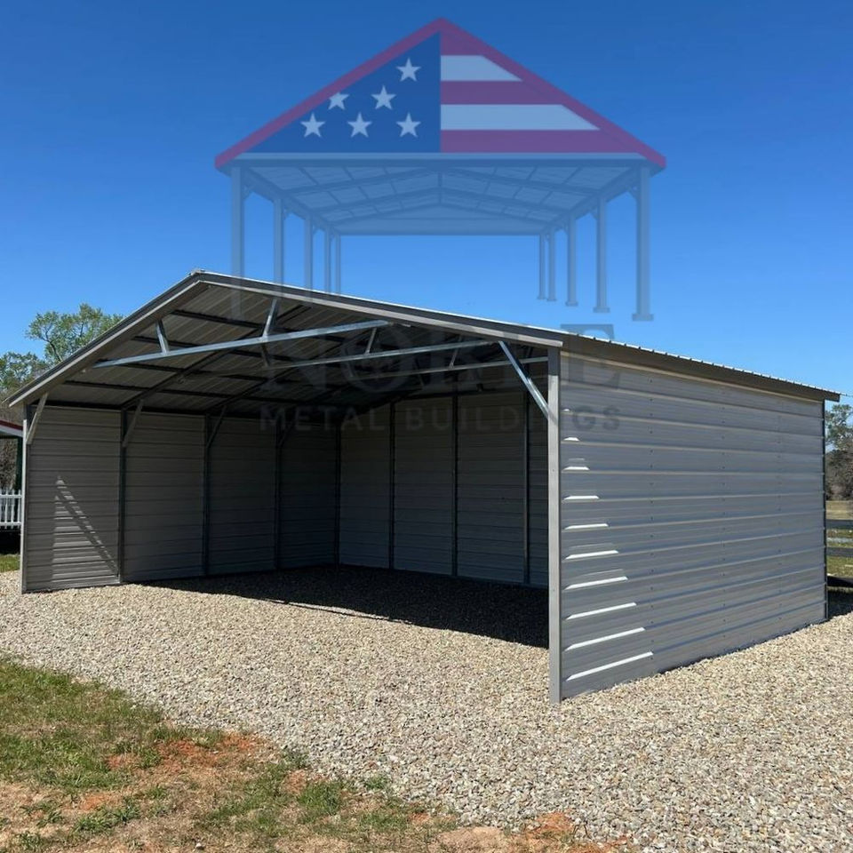 Texas metal carport with white siding and American flag roof, durable steel building on gravel lot by Noble Metal Buildings.