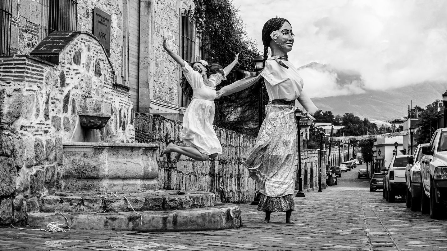 Photo performance in black and white combining Vancouver and Oaxaca settings, depicting the artist navigating a transformation machine, symbolizing freedom, play, and evolving roles as a woman.