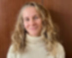 Photo of Zoë Whittall with curly, long blonde hair and white knit sweater.
