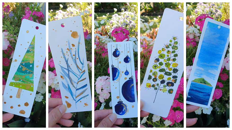 5 different hand-painted bookmarks with the following images: a decorated tree, blue and gold wildflowers, blue hanging ornaments, small green circles on a stick tree, and a small green island surrounded by blue ocean and large blue sky.
