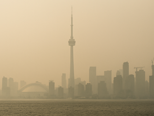 Toronto skyline covered in heavy smog, with the CN Tower barely visible through the haze, representing poor air quality conditions.