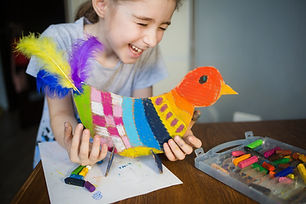 Child laughing while making a bluebird craft in speech therapy in Tennessee
