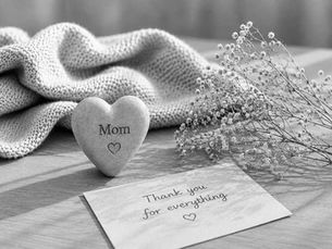 A heart with the word “Mom,” dried flowers, and a card saying “Thank you for everything” as a loving remembrance of a mother who has died.