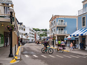 Downtown Mackinac Island with cyclists, colorful buildings, and car-free streets in Michigan