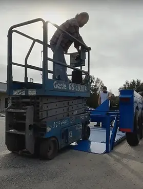 Genie Lift Being Loaded On Trailer At Ground Level