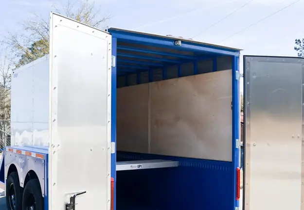 Enclosed Drop Deck Trailer with deck dropped and swinging doors open.