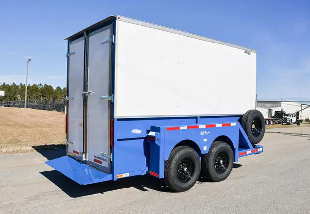 Enclosed drop deck trailer in blue powder coat and white aluminum shell. Raised Positon. Rear View.