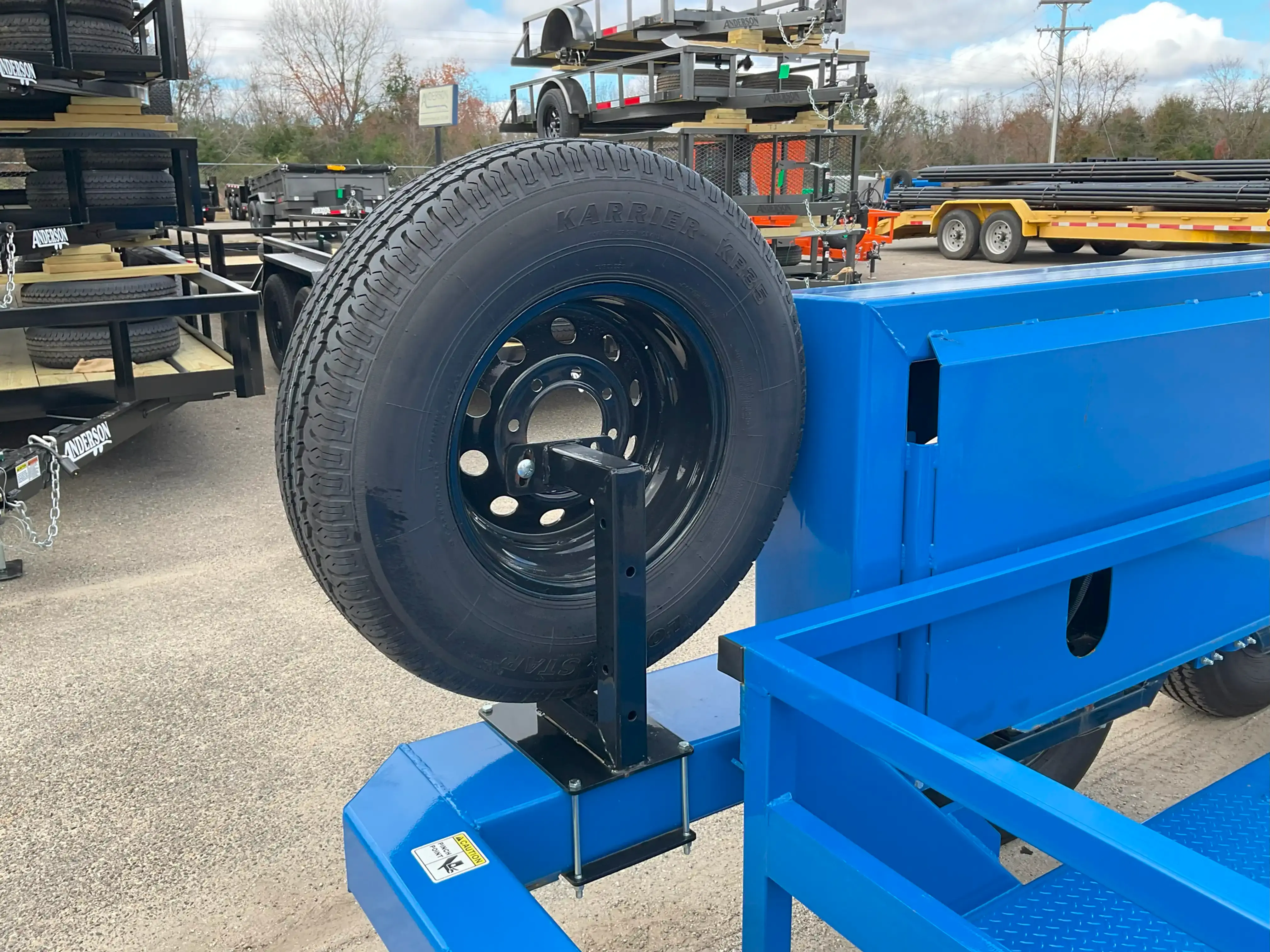 Spare tire mount for trailer in black with tire mounted. Rear View.