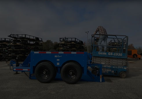 Blue drop deck trailer being loaded with scissor lift