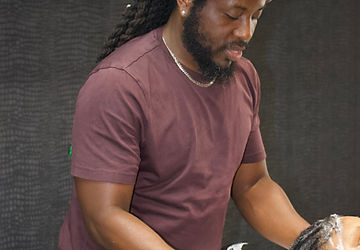 Staff at Q2 Locs Parlour Limited washing a client's hair.