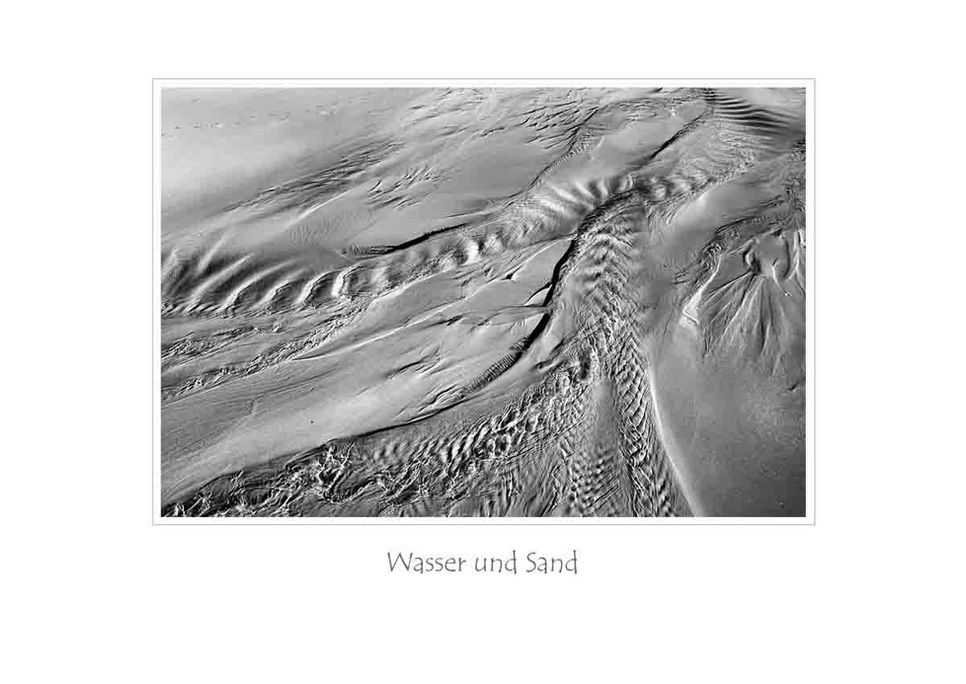 Das ins Meer zurücklaufende Wasser bildet phantastische Formen aus im feinen Sand. In Schwarzweiß sind die Formen und die Sandkörner fein herausgearbeitet. 