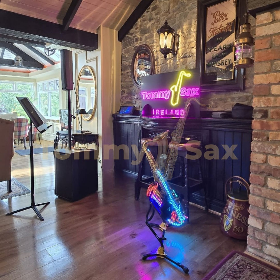 Tommy Sax Ireland drinks reception setup with LED light up tenor saxophone, music stand, and speaker ready for live performance.