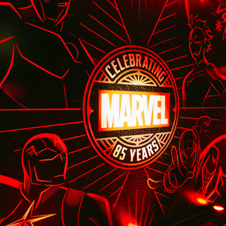 A red sign that says Celebrating Marvel 85 years with illustrations of famous marvel characters in black and red line drawings. The characters featured are Spiderman, Captain America, Captain Marvel, and Iron Man.