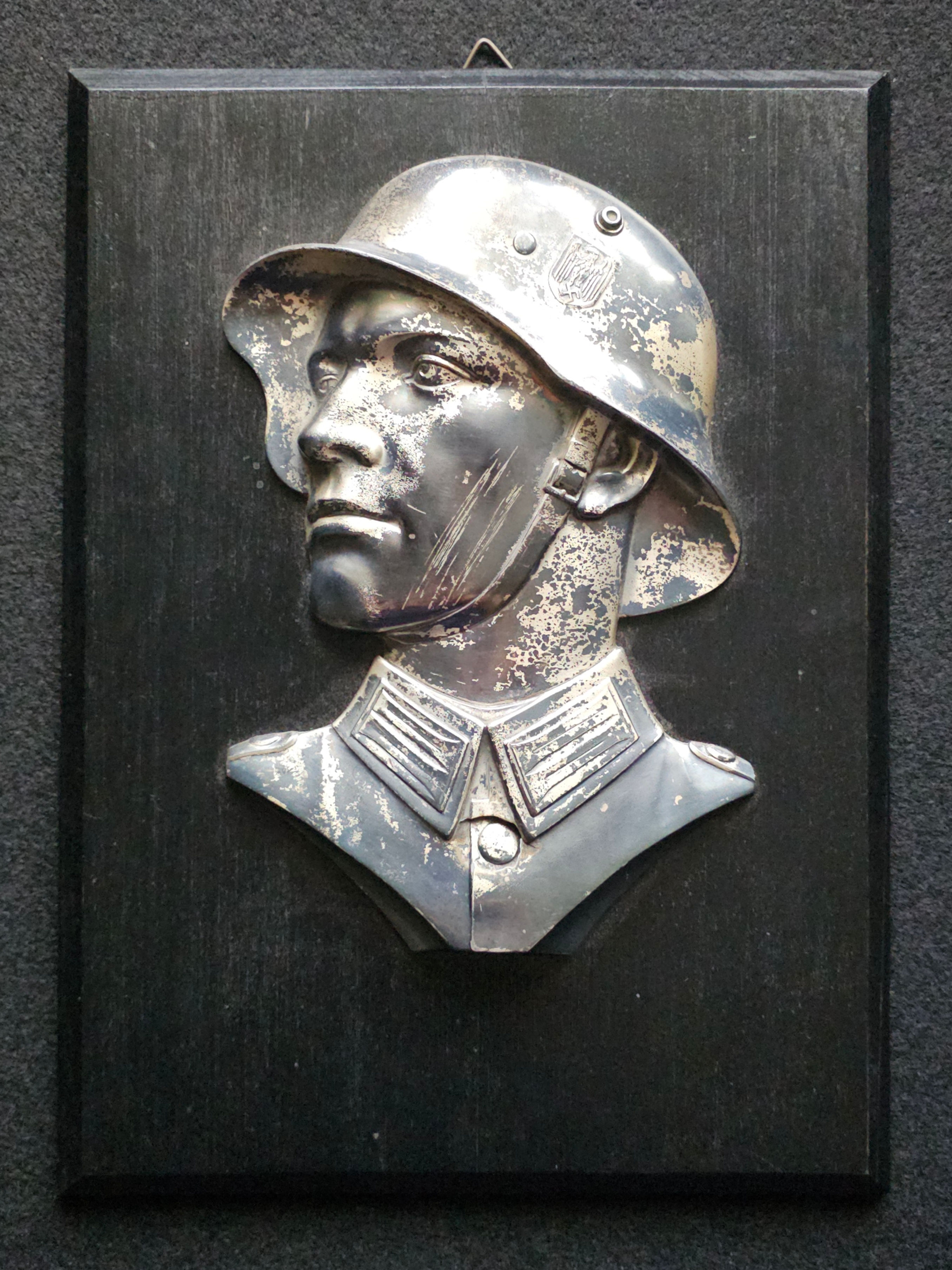 Wehrmacht Wall Plaque: Black Wooden Panel with Relief Bust of Soldier in Helmet.