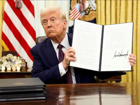 U.S. President Donald Trump holds a signed executive order in the Oval Office of the White House, in Washington, U.S., March 14, 2025.