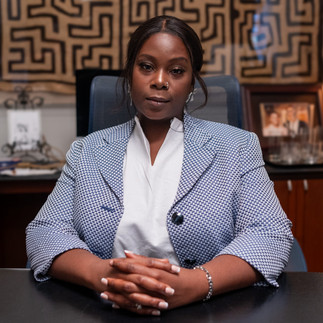 Lead actress Precious Oginni as Beula Johnson sits behind her work desk on set