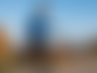 Homme de 45 à 50 ans marchant de profil sur une pente douce en milieu urbain, sous un ciel bleu d’automne. Il porte une tenue sportive légère et illustre le thème de la marche comme outil de santé et de mieux-être.