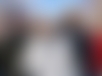 Groupe de personnes de différents âges et origines marchant ensemble à l’extérieur par temps frais, souriantes, dans un environnement naturel lumineux.