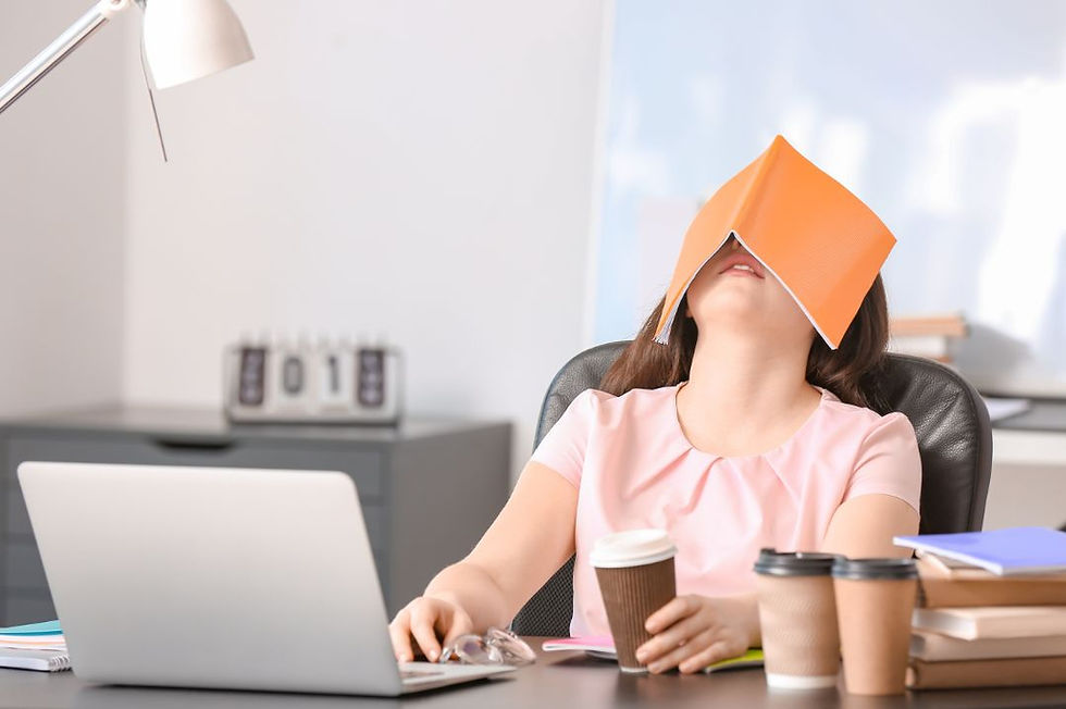 Tired woman in front of laptop with 3 cups of coffee beside her.