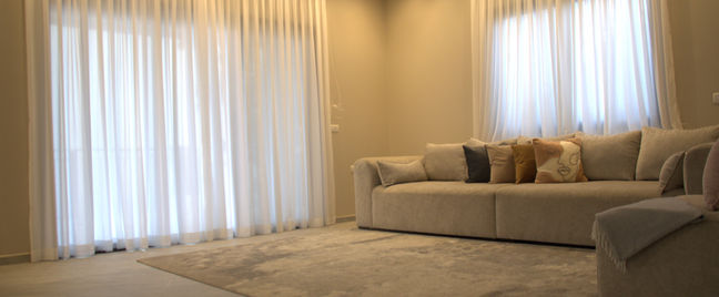 סלון מרווח בעל חלונות גדולים שנותנים אור טבעי רב. הסלון מעוצב בגוונים בהירים וטבעיים שנותנ