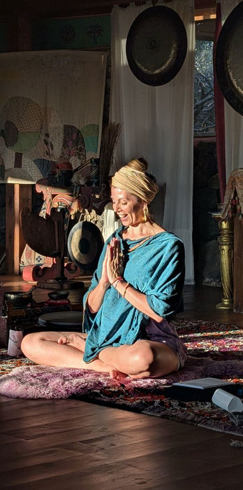 Yoga teacher Victoria leading a seated meditation and breathing exercise during a daily Lanzarote Yoga session inside the beautiful circular yoga room.