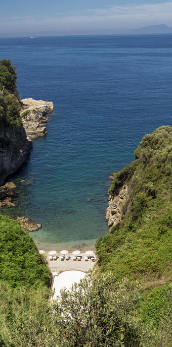 Scenic coastline view with cliffs dropping to the blue sea, highlighting the natural beauty of the retreat location.