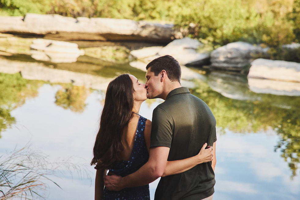 Engagement moment by the river at McKinney Falls State Park Austin TX during a surprise proposal.
